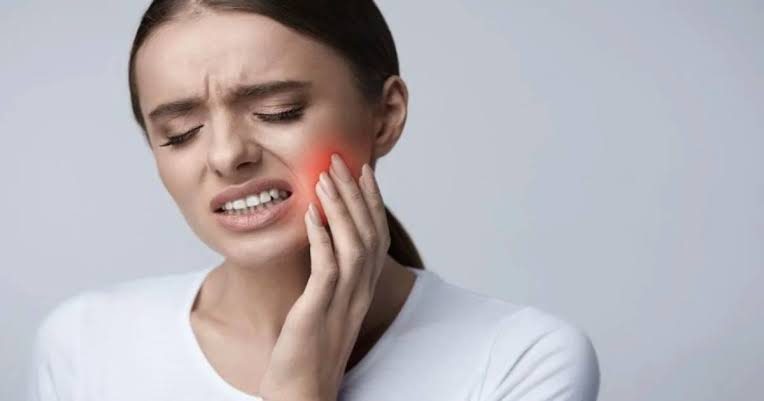 A woman holding her jaw in pain from a toothache